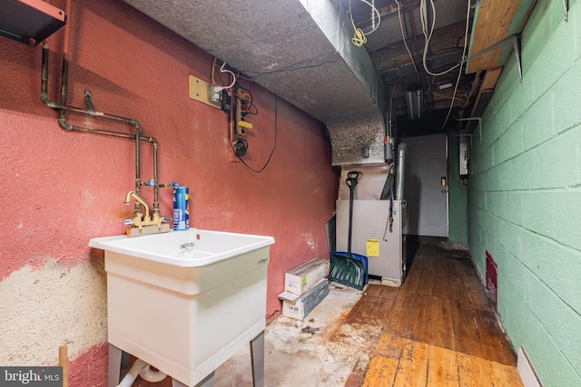 unfinished basement with hardwood / wood-style flooring and a sink