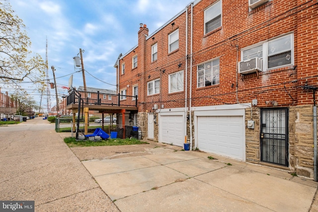 exterior space with an attached garage, driveway, and cooling unit