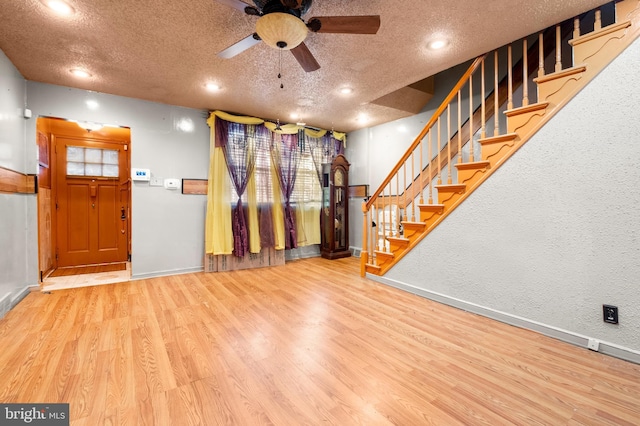 entryway with wood finished floors, a textured ceiling, and ceiling fan