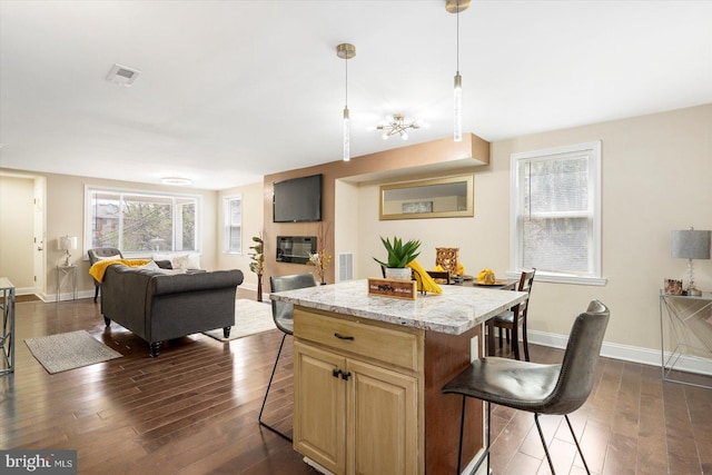 4548 Derby Manor Dr, Baltimore, MD 21215 - kitchen with dark wood-style floors, a breakfast bar, visible vents, baseboards, and open floor plan