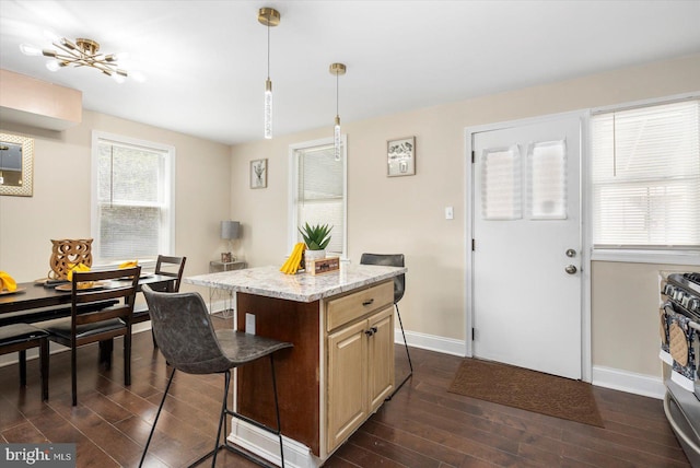 4548 Derby Manor Dr, Baltimore, MD 21215 - kitchen featuring stainless steel range with gas cooktop, baseboards, dark wood-style flooring, and a breakfast bar area