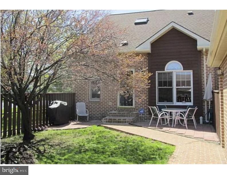 rear view of property featuring fence, a patio, and brick siding