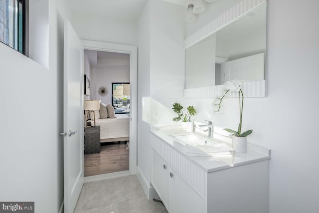 ensuite bathroom featuring baseboards, ensuite bath, and vanity
