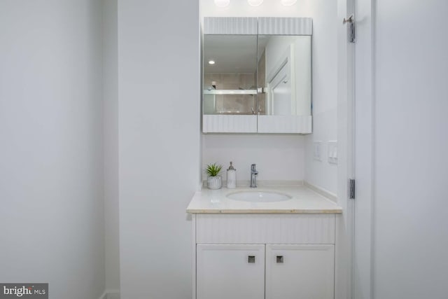 bathroom featuring walk in shower and vanity