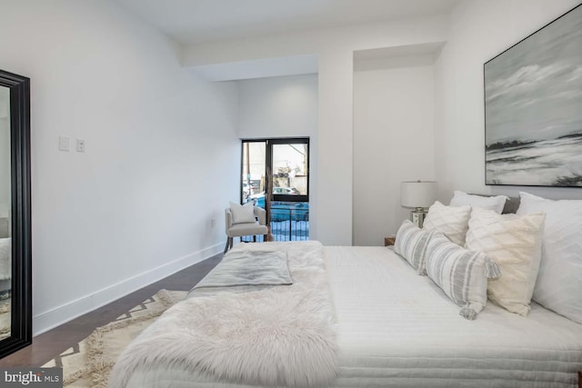 bedroom featuring wood finished floors, access to exterior, and baseboards