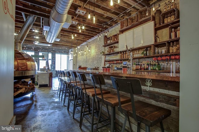 bar featuring concrete floors and a dry bar