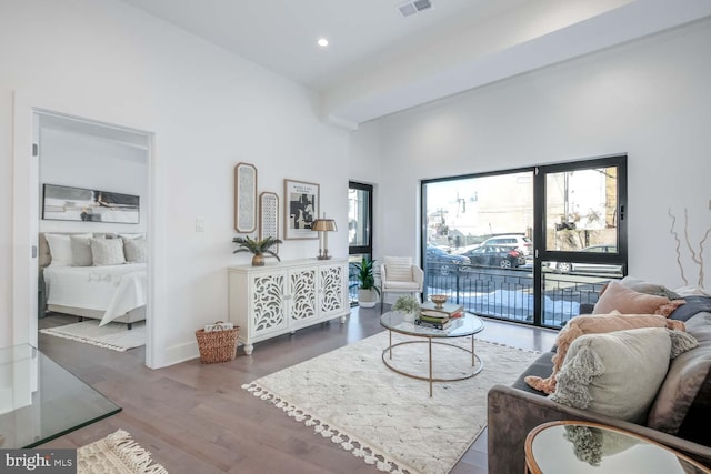 living area featuring a wealth of natural light, wood finished floors, visible vents, and recessed lighting