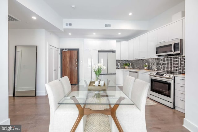 dining room featuring recessed lighting, wood finished floors, and visible vents