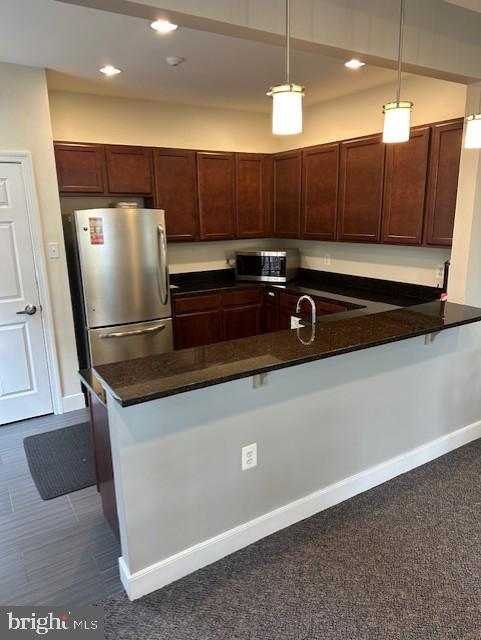 9200 Charleston Dr Unit 408, Manassas, VA 20110 - kitchen featuring stainless steel appliances, dark countertops, a peninsula, hanging light fixtures, and recessed lighting