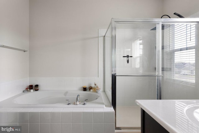 bathroom with vanity, a bath, and a stall shower