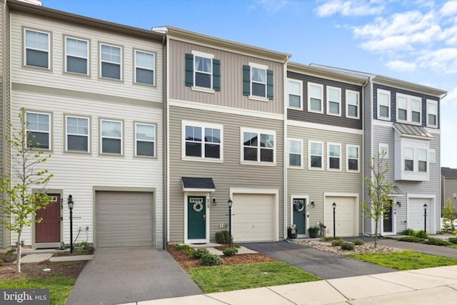 multi unit property featuring a garage and driveway