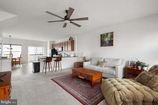 carpeted living room with ceiling fan