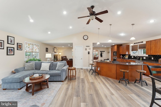8807 Falkstone Ln, Alexandria, VA 22309 - living area featuring light wood-style floors, vaulted ceiling, a healthy amount of sunlight, and recessed lighting