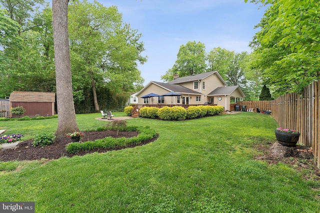 8807 Falkstone Ln, Alexandria, VA 22309 - view of yard featuring an outdoor structure, a deck, and a storage unit