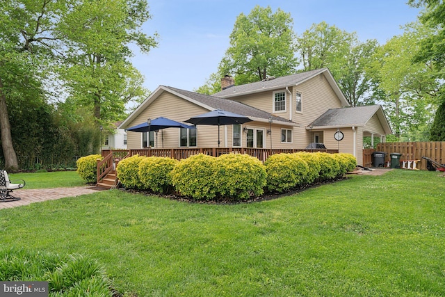 8807 Falkstone Ln, Alexandria, VA 22309 - back of property featuring a chimney, a lawn, fence, a shingled roof, and a wooden deck