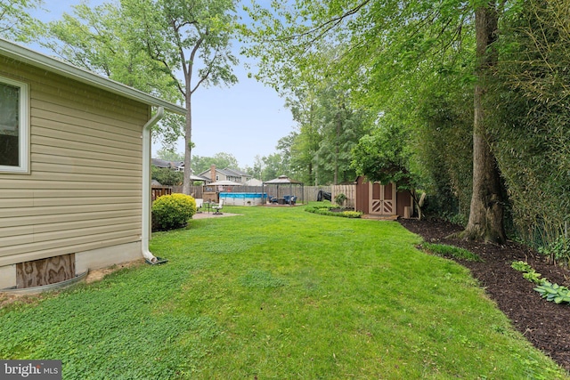 8807 Falkstone Ln, Alexandria, VA 22309 - view of yard featuring an outdoor structure, a fenced in pool, a fenced backyard, and a storage unit
