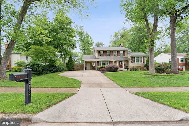 8807 Falkstone Ln, Alexandria, VA 22309 - view of front of home with concrete driveway, fence, a chimney, and a front lawn
