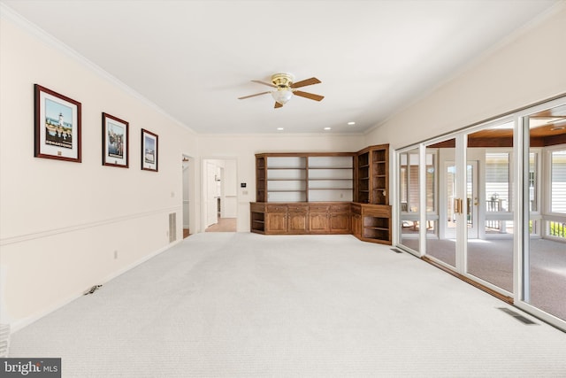 unfurnished room featuring crown molding, carpet, a ceiling fan, and visible vents