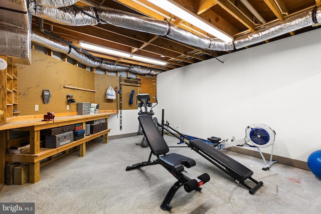 exercise room featuring baseboards and a workshop area