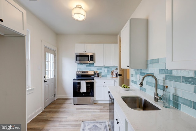 615 Burke Ave, Jenkintown, PA 19046 - kitchen with stainless steel appliances, a sink, light stone countertops, tasteful backsplash, and white cabinetry