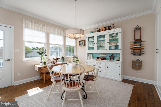 dining area featuring crown molding, baseboards, plenty of natural light, and dark wood-style flooring