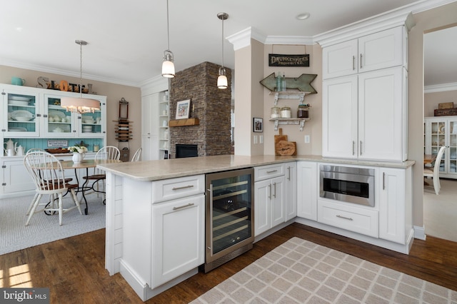 kitchen with crown molding, a peninsula, wine cooler, and dark wood-style floors