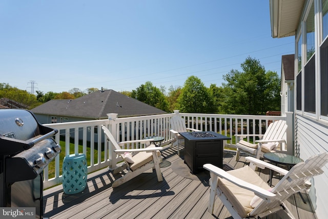deck with area for grilling and an outdoor fire pit