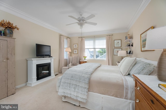 bedroom featuring a ceiling fan, a glass covered fireplace, ornamental molding, and light carpet
