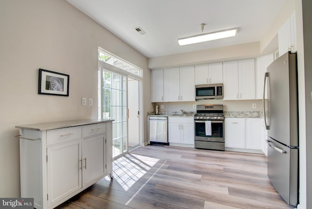 11405 Windleaf Ct Unit K # 24, Reston, VA 20194 - kitchen featuring white cabinetry, a sink, light wood-style floors, stainless steel appliances, and visible vents