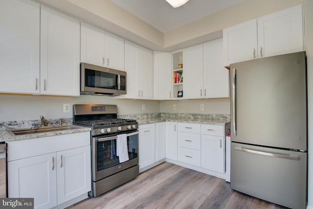 11405 Windleaf Ct Unit K # 24, Reston, VA 20194 - kitchen featuring light wood finished floors, a sink, stainless steel appliances, open shelves, and white cabinetry