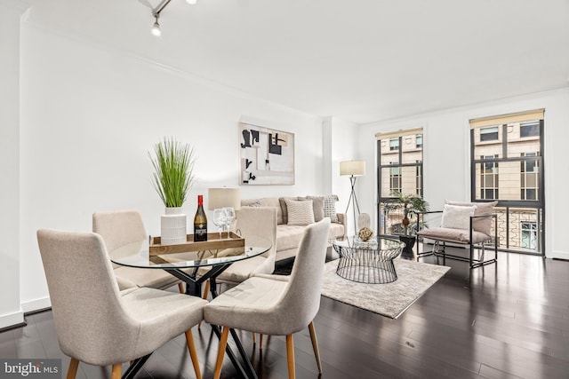 dining area with baseboards, ornamental molding, and dark wood-style floors