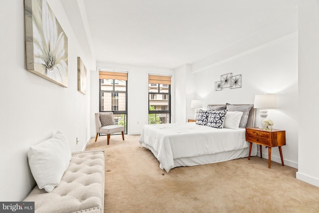bedroom with baseboards and light carpet