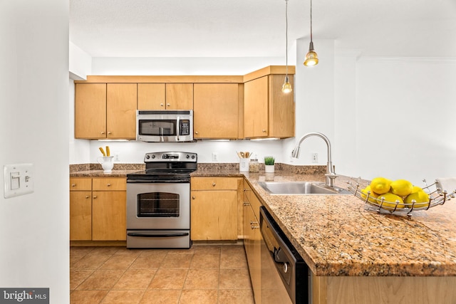 kitchen with appliances with stainless steel finishes, a sink, stone countertops, a peninsula, and decorative light fixtures