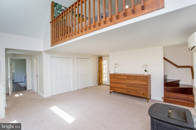 interior space with baseboards, carpet, high vaulted ceiling, and stairway