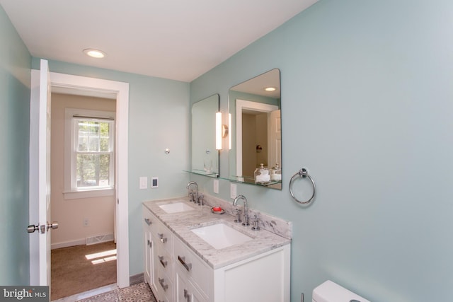 bathroom with baseboards, a sink, visible vents, and recessed lighting