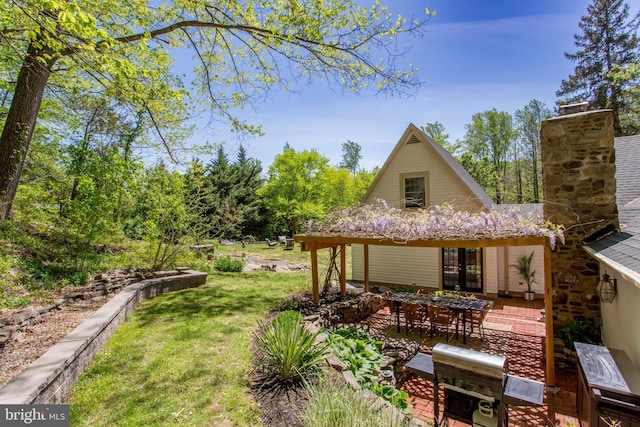exterior space featuring a patio area, a yard, and a chimney