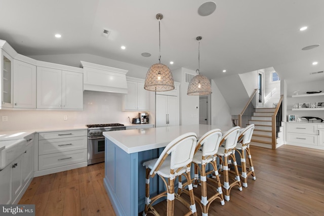 15 W Harding Ave, Long Beach Township, NJ 08008 - kitchen featuring high end stainless steel range, a center island, hardwood / wood-style floors, white cabinetry, and vaulted ceiling