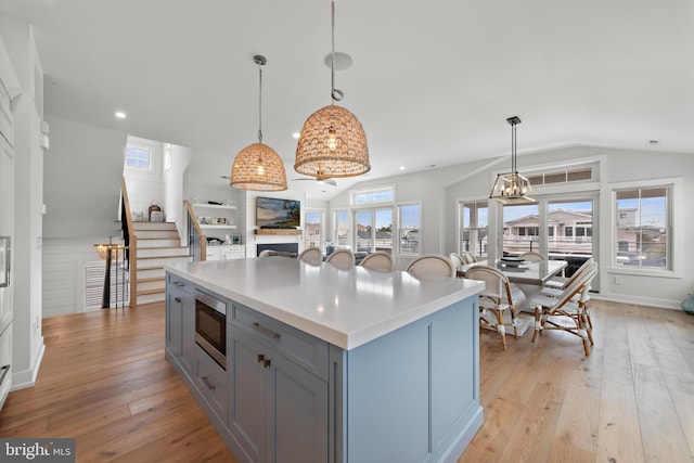 15 W Harding Ave, Long Beach Township, NJ 08008 - kitchen with gray cabinetry, stainless steel microwave, lofted ceiling, light countertops, and light wood finished floors