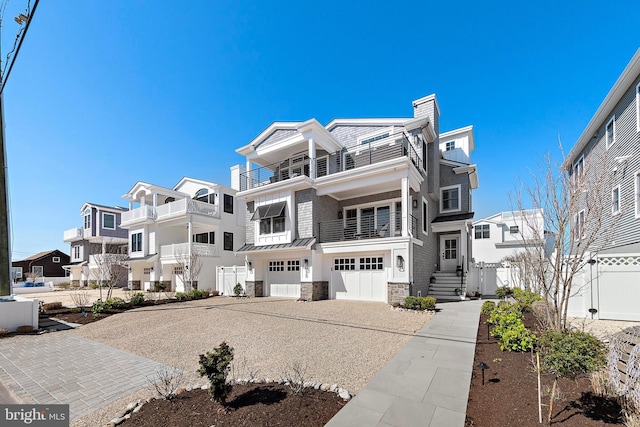 15 W Harding Ave, Long Beach Township, NJ 08008 - view of front of home featuring driveway, stone siding, a standing seam roof, an attached garage, and a chimney