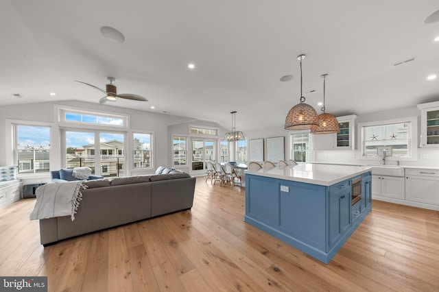 15 W Harding Ave, Long Beach Township, NJ 08008 - kitchen featuring a sink, blue cabinetry, white cabinetry, light wood-type flooring, and lofted ceiling