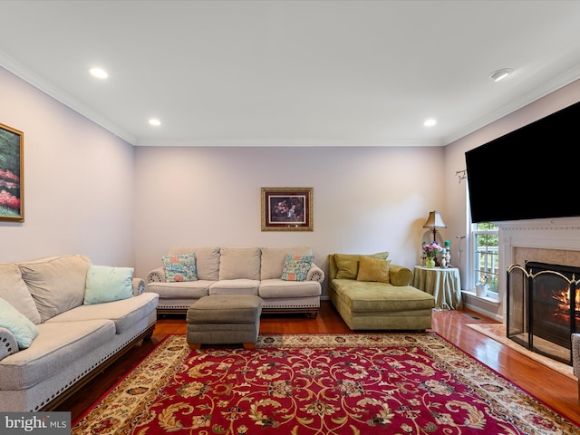 living room with a fireplace, wood finished floors, recessed lighting, and ornamental molding