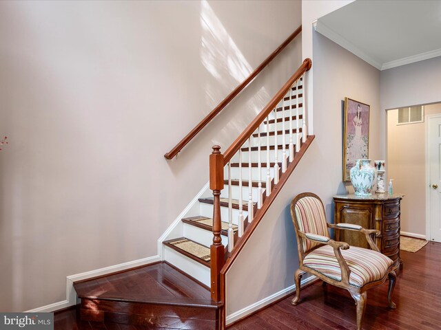 staircase featuring baseboards, visible vents, wood finished floors, and crown molding