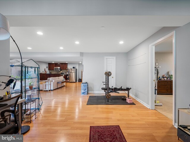 workout room featuring light wood-style floors, recessed lighting, and baseboards