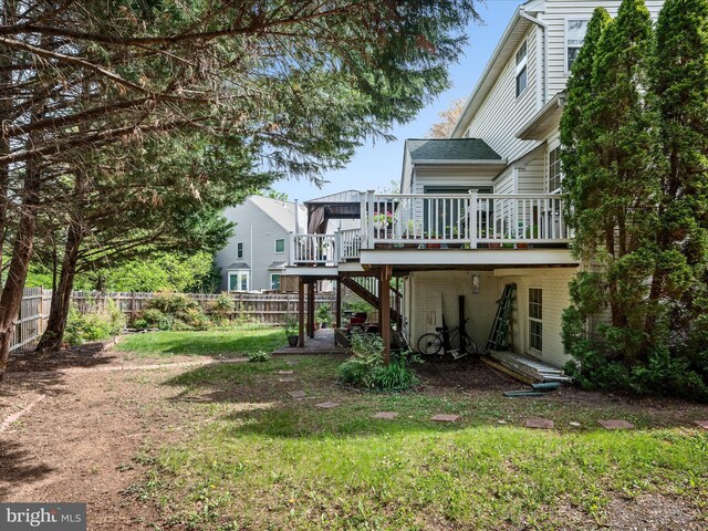 view of yard featuring a deck, stairs, and a fenced backyard