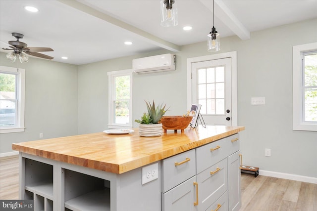 kitchen featuring a wall mounted air conditioner, light wood-style floors, beamed ceiling, healthy amount of natural light, and recessed lighting