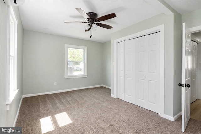 unfurnished bedroom featuring carpet flooring, baseboards, a closet, and a ceiling fan
