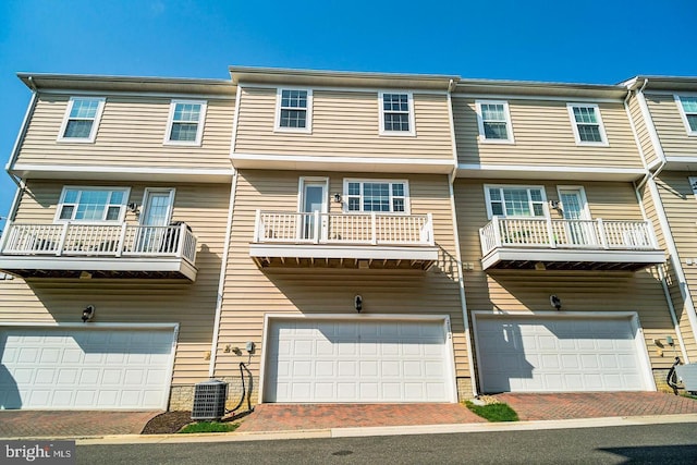 view of front of home with central air condition unit, an attached garage, and driveway