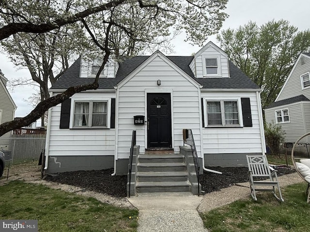 view of front of home featuring a shingled roof and fence