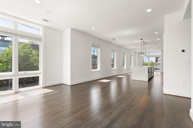 unfurnished living room with recessed lighting, baseboards, dark wood-type flooring, and visible vents