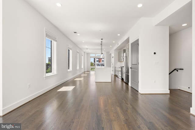 unfurnished living room with recessed lighting, dark wood-style flooring, baseboards, and visible vents